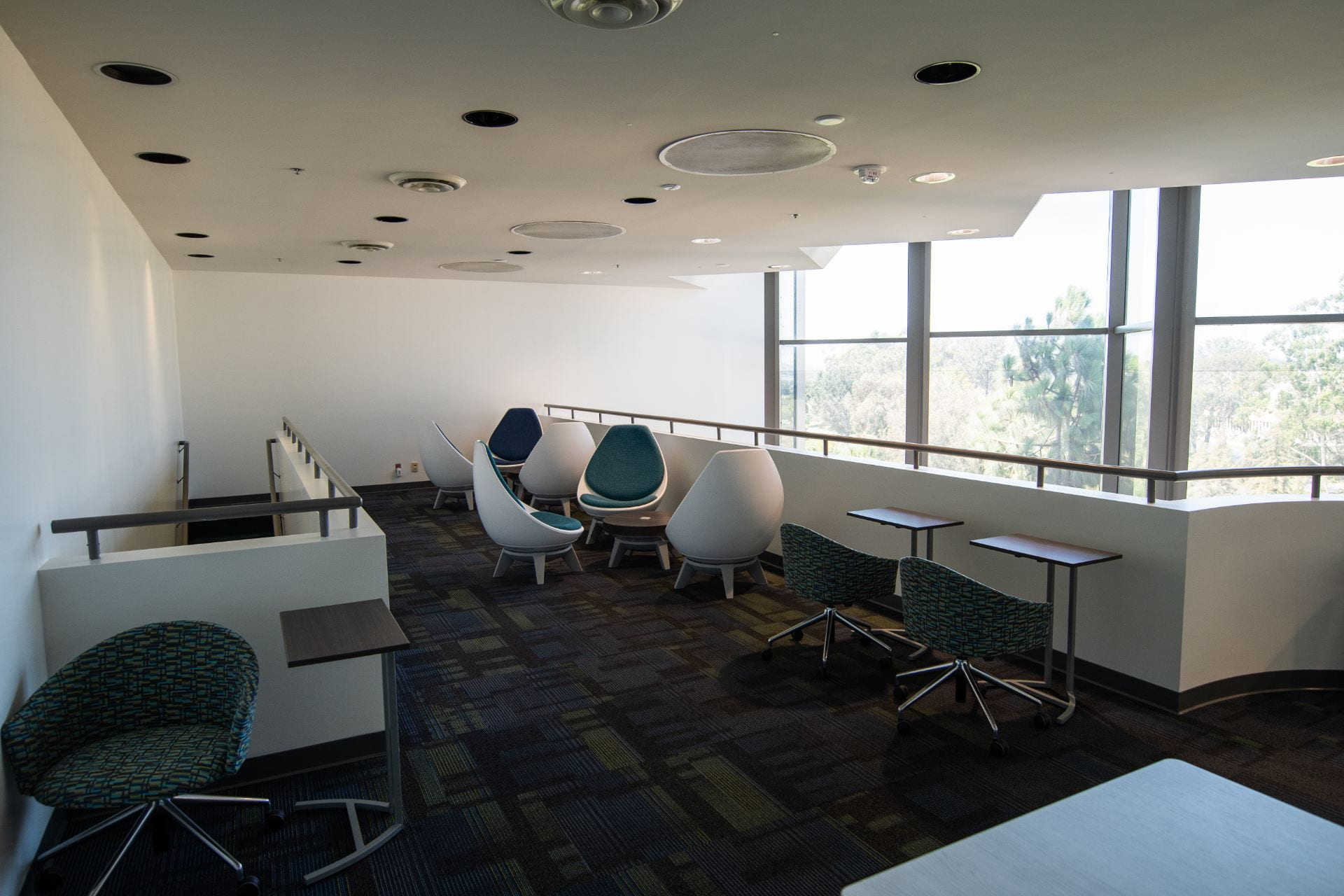 Top floor of Student Excellence Center, room arranged with chairs and tables for leisure
