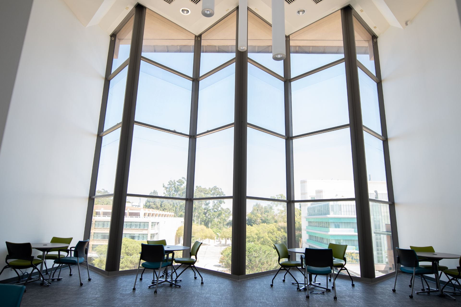 Tables facing a large window overlooking UCI campus